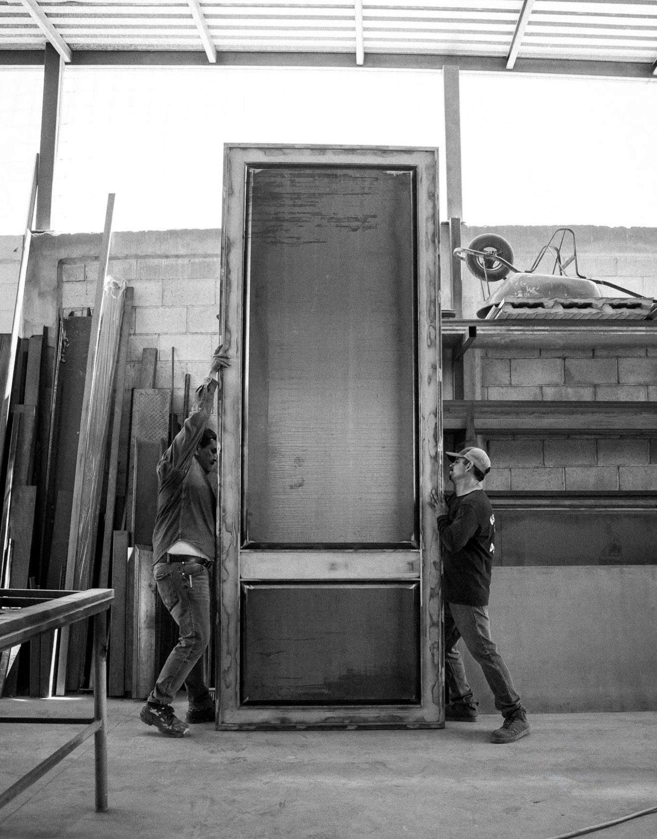 Workshop team handling a steel entry door